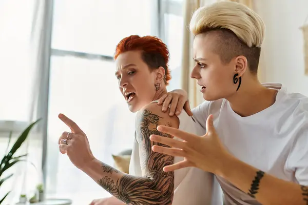 タトゥーを持つ2人の女性は スタイリッシュなリビングルームで熱い議論に従事しています ショートヘア Lgbtライフスタイル明らか — ストック写真