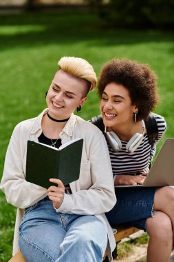 İki genç kadın, sıradan giyinmiş, bir bankta oturuyor, bir kitaba dalmış, huzurlu bir anın tadını çıkarıyorlar..