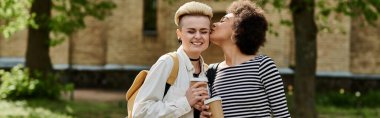 A moment of love shared between two young women walking in a park, exchanging a heartfelt kiss. clipart