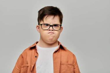 A little boy with Down syndrome with glasses showcasing his playful and mischievous side. clipart