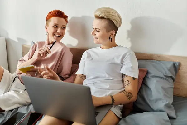 Two Women Short Hair Sitting Bed Engaged Using Laptop Together — kuvapankkivalokuva
