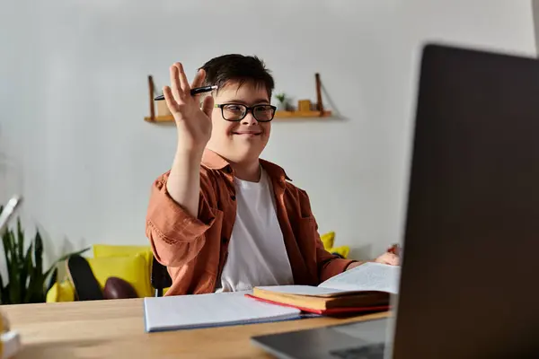 stock image boy with Down syndrome at home desk using laptop.