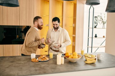 Mutlu bir eşcinsel çift, modern bir mutfakta birlikte kahvaltı ediyor. Sevgi ve beraberlik sergiliyorlar..