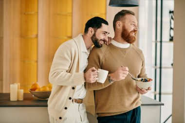Two men savor a cup of coffee in a kitchen, basking in each others company with smiles in a cozy modern apartment. clipart