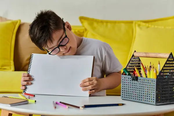 stock image adorable boy with Down syndrome with glasses holds a piece of paper.