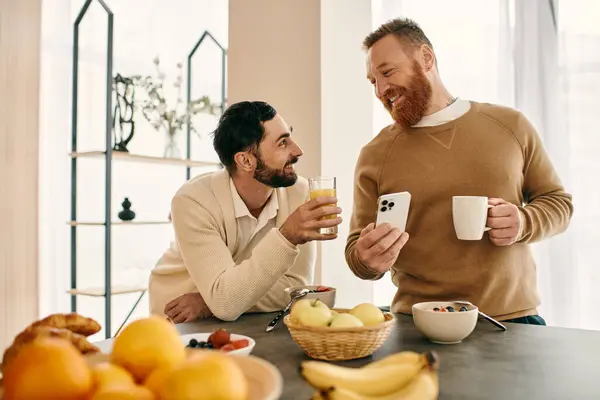 stock image Two men engaged in a lively conversation at a table in a modern apartment.