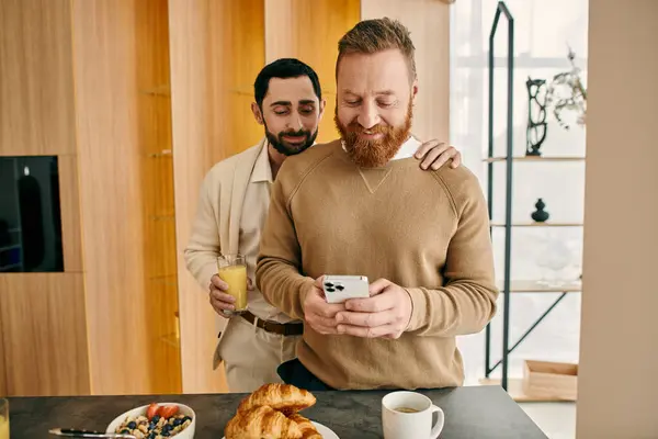 stock image man engrossed in phone while spending time together with partner in a modern kitchen.