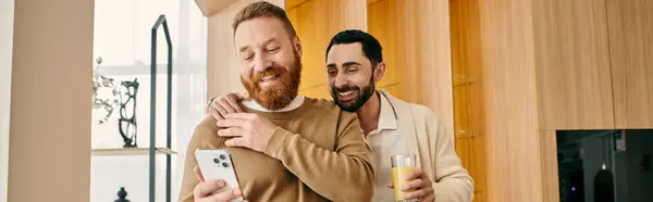 stock image Two men in front of wall with picture of bearded man, happy and in love.