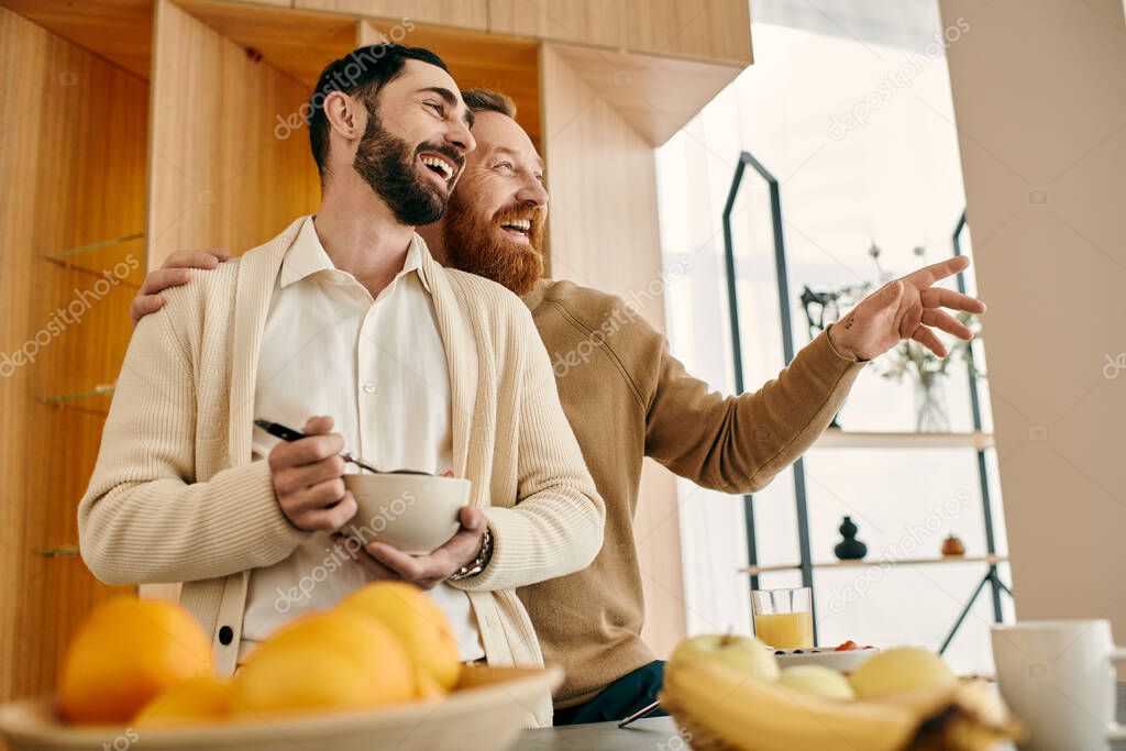 Two joyful men arranging a bowl of fresh fruit in a modern kitchen, sharing a loving moment together.