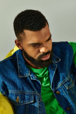 Sandalyede oturan sakallı bir adam, düşüncelere dalmış, etrafındaki dünyayı düşünüyor..