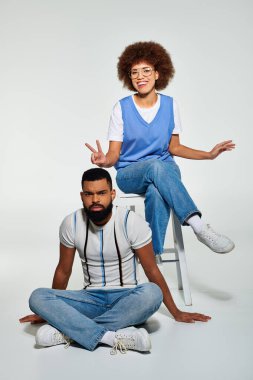 Afro-Amerikalı bir erkek ve kadın şık giyinmiş, yakın oturuyorlar, dostluk ve dostluk sergiliyorlar..