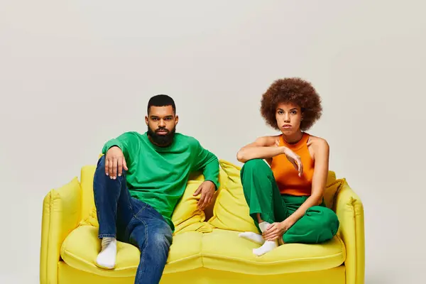 African American Friends Vibrant Clothes Sit Yellow Couch Showcasing Friendship — Stok fotoğraf