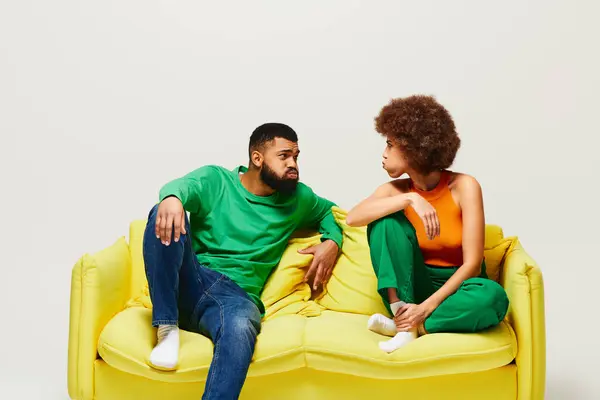 Happy African American Friends Vibrant Clothes Sitting Yellow Couch Showcasing — Stok fotoğraf