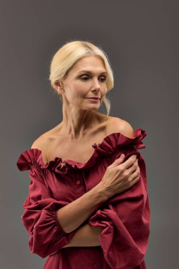 Şık, zarif, kırmızı bluzlu bir kadın poz veriyor..