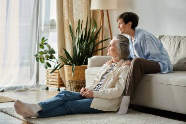 Two senior women sit peacefully by a window. clipart