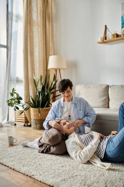 Two women lie peacefully on the floor in a cozy living room. clipart