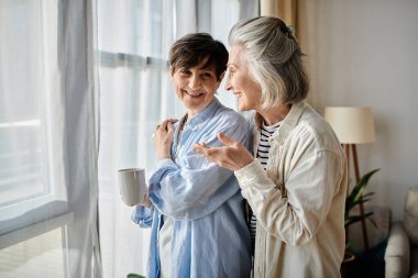Pencerenin yanında duran iki yaşlı kadın, sohbete dalmışlar..