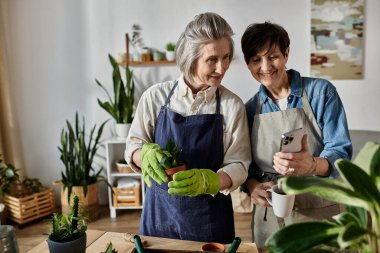 Two women in aprons admiring plants together. clipart