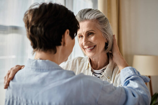 A woman lovingly embraces her female partner in a cozy living room.
