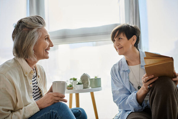 Две пожилые женщины ведут оживленную беседу на диване.