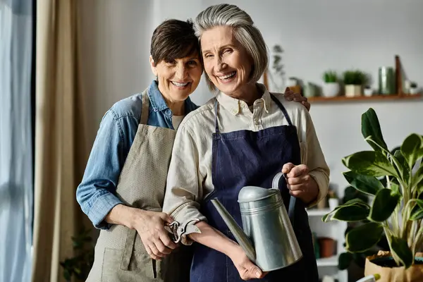 stock image Two women in aprons standing together in a kitchen.