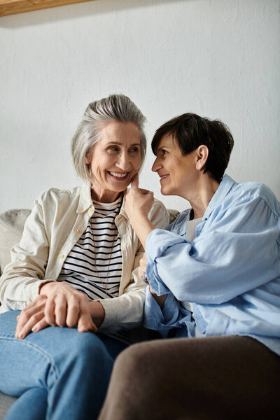 Two women, a mature lesbian couple, engage in a heartfelt conversation on a cozy couch.