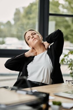 Middle-aged woman in distress sits on office chair. clipart