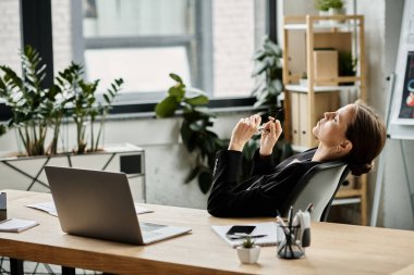 Middle-aged woman overwhelmed with stress as she works at her desk with a laptop.