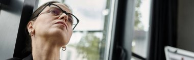 Woman in glasses gazes away, depression.