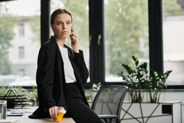 Businesswoman in office talking on phone, multitasking. clipart