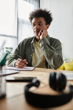 Young man, African American, studying at desk.