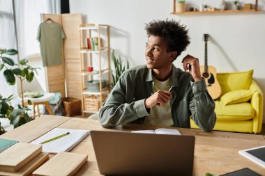Young man multitasking with laptop.