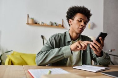 Young man deeply engrossed in digital device while seated at table