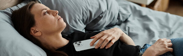 Middle-aged woman finds solace in her phone amidst a mental breakdown.