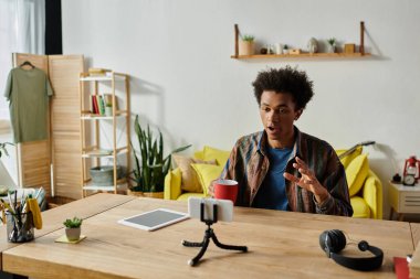 Young African American male blogger engaging with tablet during video call.