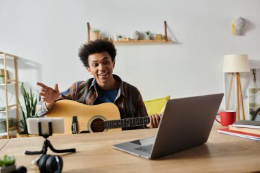 Young man strums acoustic guitar in front of phone, engaging with online audience.