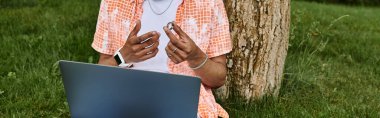 African American man with laptop outdoors. clipart