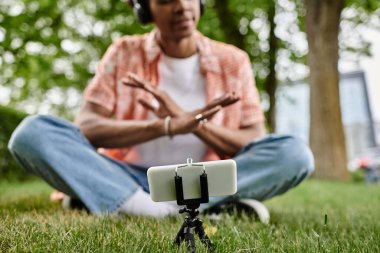 man enjoying music on grass with cellphone.