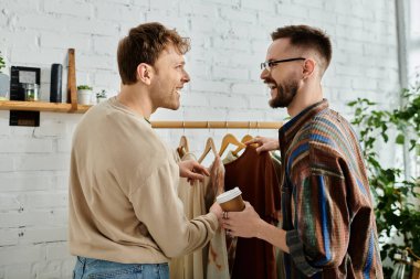 Two male fashion designers collaborate on stylish clothing in a workshop. clipart