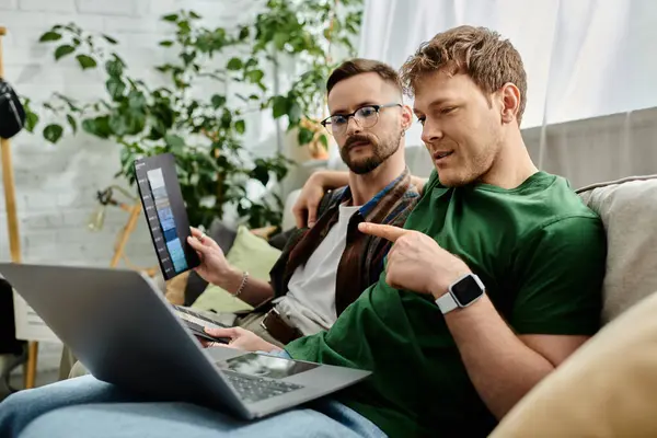 stock image Two men in a designer workshop, engrossed in working on a laptop.