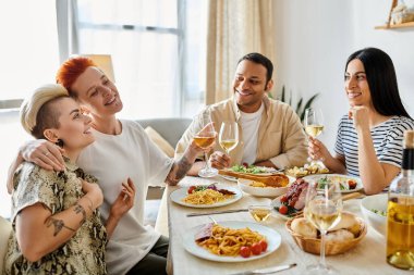 Çeşitli arkadaşlar, gülme ve sevgi dolu bir yemek için bir masanın etrafında toplanırlar..