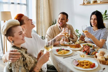 A diverse group of friends enjoys food and drinks around a table at home. clipart