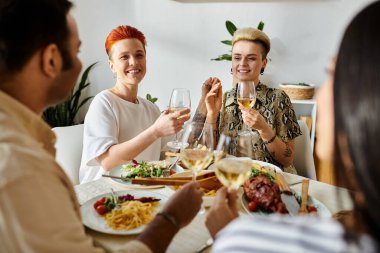 Çeşitli arkadaş grupları bir masada birlikte yemek yiyorlar..