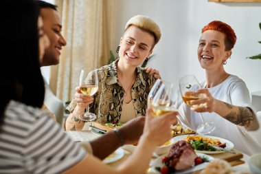 Çeşitli bir grup kadın bir bardak şarap eşliğinde kahkahalar ve hikayeler anlatıyor..