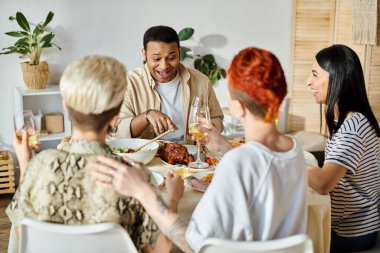 Sevgi dolu lezbiyen bir çift de dahil olmak üzere çeşitli arkadaş grupları bir masanın etrafında yemek paylaşırlar..