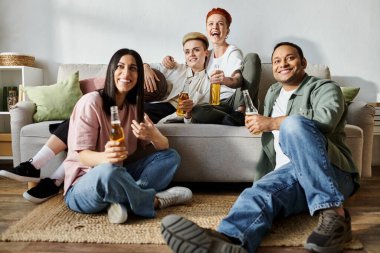 Arkadaşlar ve çiftler evdeki kanepenin üzerinde mutlu mesut otururlar..