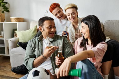 Çeşitli gruplar kanepede bira içiyor..