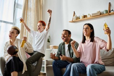 Bir grup arkadaş ve sevecen lezbiyen çift koltukta rahatça otururlar..