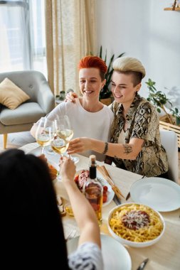 Diverse group enjoying food and drinks at the table. clipart