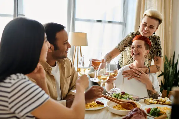 stock image A loving lesbian couple hosts a dinner with diverse friends at home, surrounded by warmth and companionship.